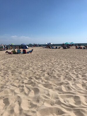 A sandy beach with people, tents, and umbrellas. - Across from Craigville Beach; updated house with 4 BRs & firepit. Hyannis Area (Barnstable)