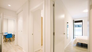 Une chambre d’hôtel moderne comprenant un lit, une salle de bain et un coin repas avec des chaises et une table.