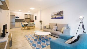 Un salon moderne comprenant un canapé, une table basse et un coin repas avec des chaises et une table.