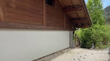 A wooden building with a gravel driveway and a clear sky.