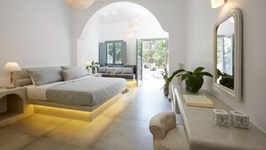 Ein modernes Schlafzimmer mit Bett, Nachttisch, Lampe und einem großen Spiegel.