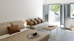 Ein modernes Wohnzimmer mit einer Couch, einem Couchtisch und Pendelleuchten.