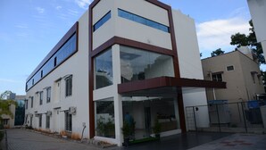 A modern two-story building with large windows and a flat roof. - Hotel RR Grand (Bengaluru)