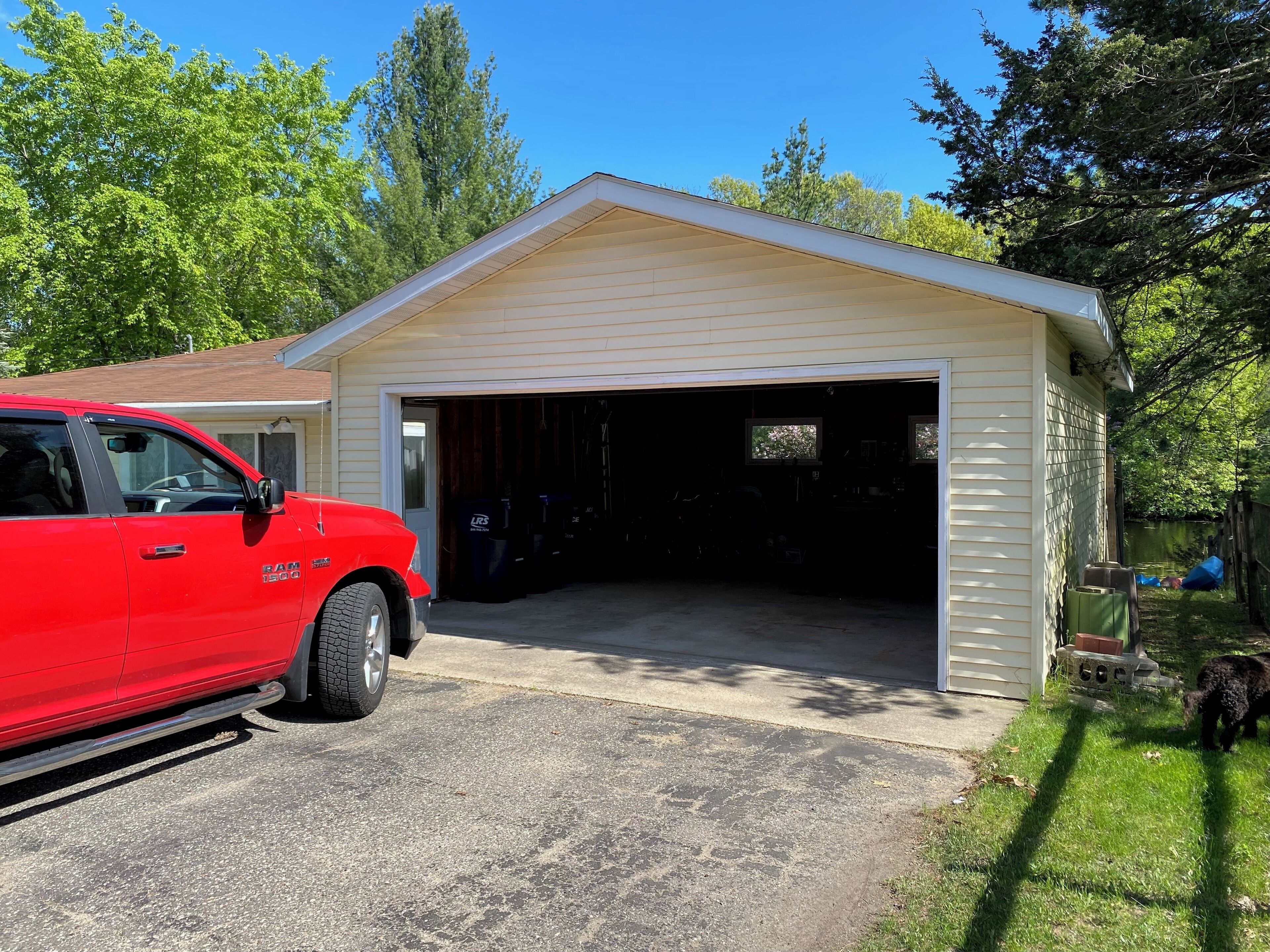 A garage with a red truck parked outside.