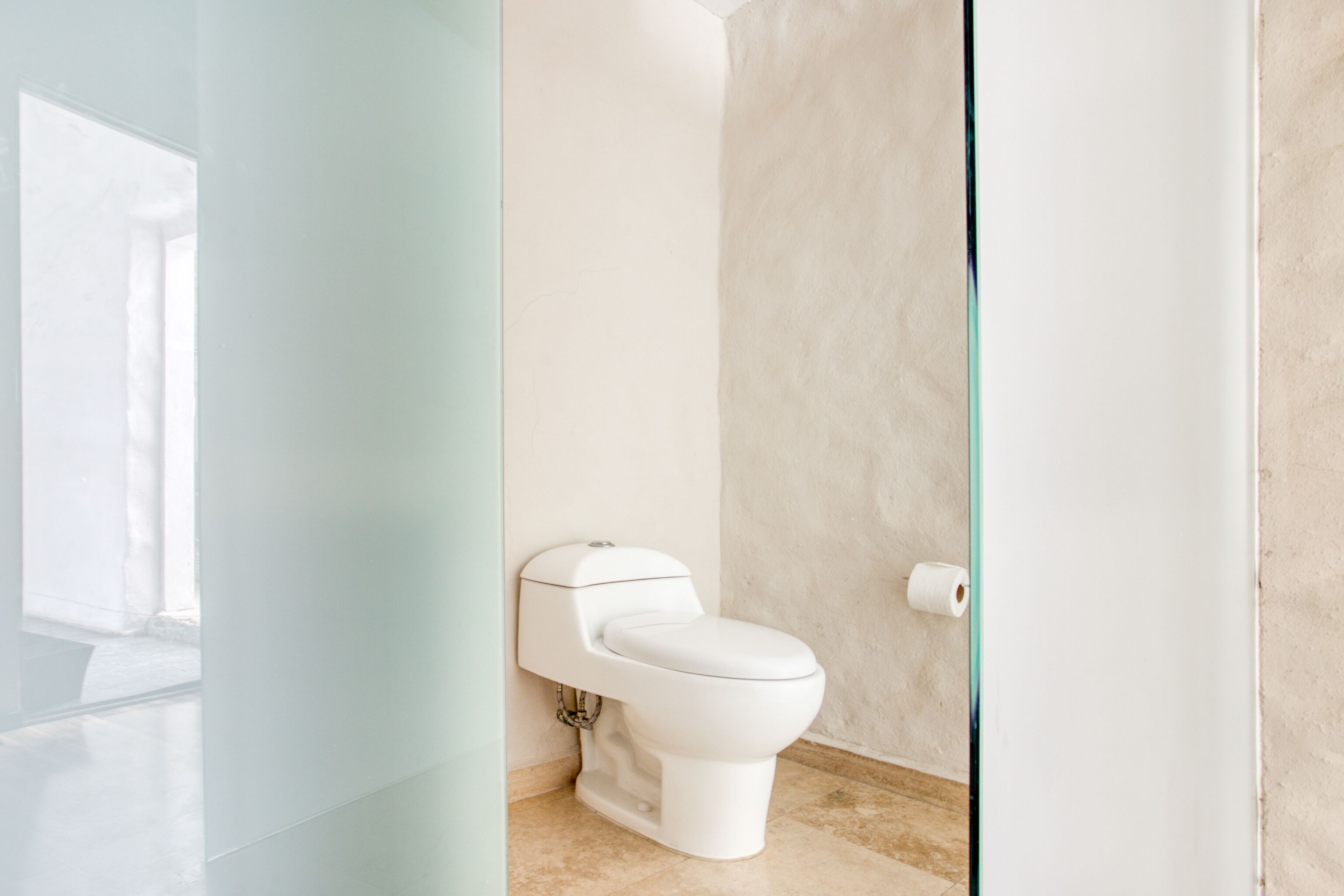Ein modernes Badezimmer mit Toilette, Handtuchhalter und Toilettenpapierhalter.