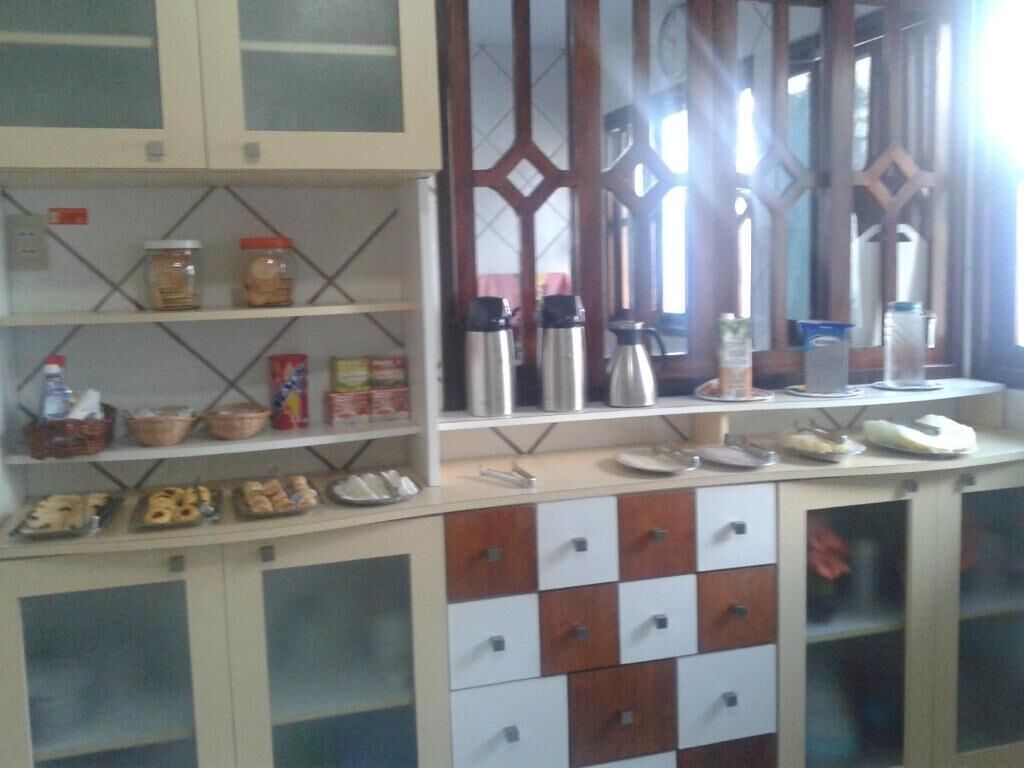A kitchen with cabinets, shelves, and various kitchen appliances.