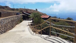 A concrete pathway with metal railings leading uphill, flanked by a stone wall and vegetation. - Traditional rural house, tranquility, landscape, renewable energy and WIFI (Taibique)