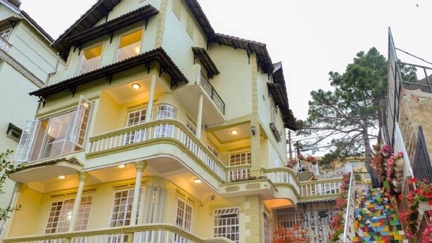 Un edificio de varios pisos con balcones y un colorido diseño geométrico en el suelo.