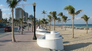 Ein Strand mit Palmen, ein Schild für Port Lander Beach und eine weiße, runde Struktur.