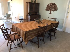 A dining room with a large wooden table, six chairs, a glass-top coffee table, and a wall-mounted tree decoration. - Welcome, enjoy your own PRIVATE POOL and LAKEFRONT Dock. Fish & Kayak (Lake Placid)
