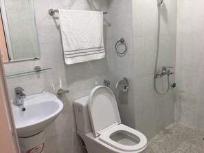 A bathroom with a sink, toilet, and shower. - Dreamer Homestay (Bai Chay)