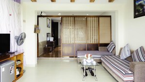 A modern living room with a sofa set, a coffee table, and a television. - Ho May Resort (Ho Chi Minh City)