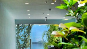 Ein modernes Interieur mit Blick auf einen See und Berge.