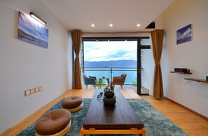 Loftsrom – deluxe, utsikt mot innsjø | Oppholdsområde | Flatskjerm-TV