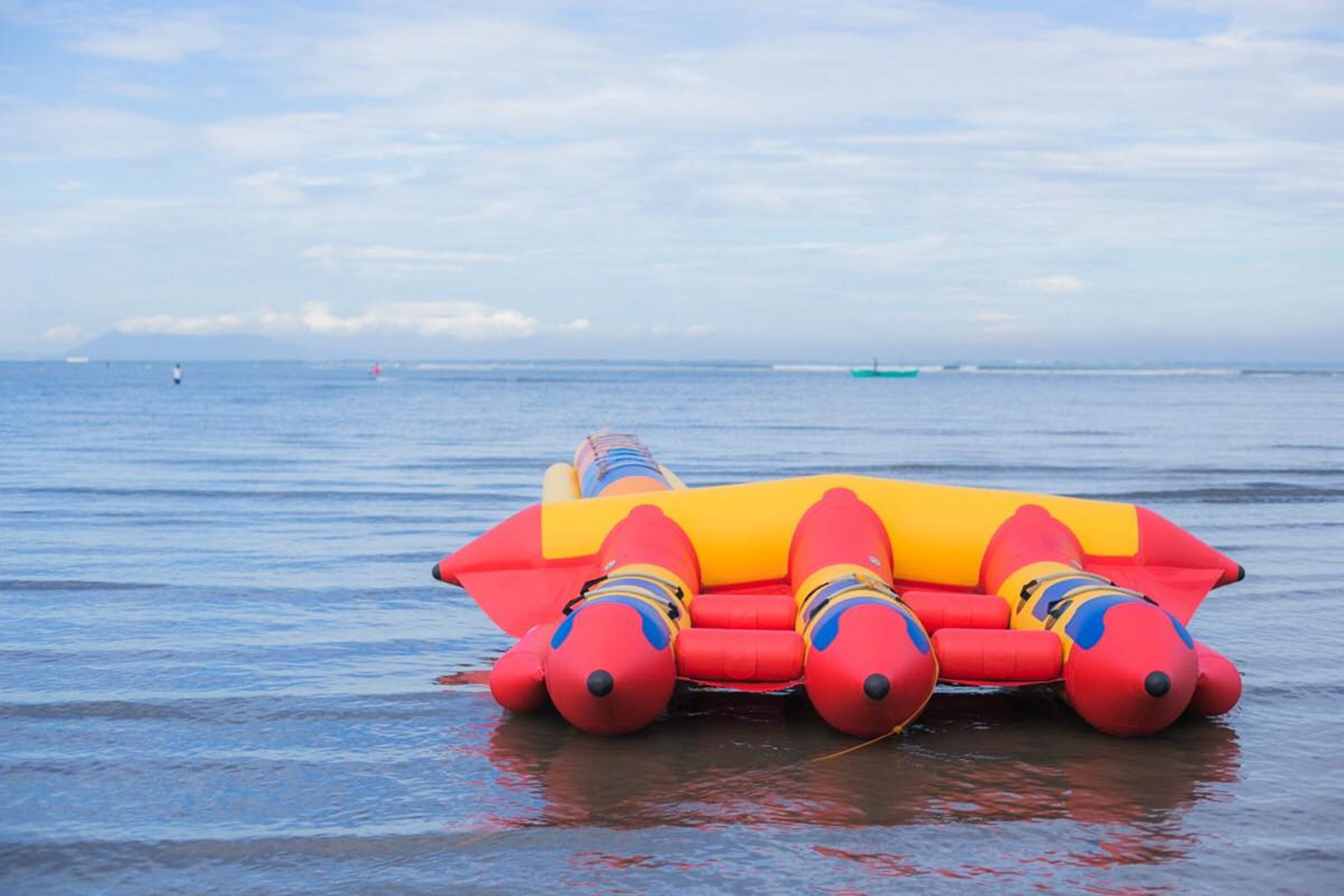A red and yellow inflatable raft floating on calm water.