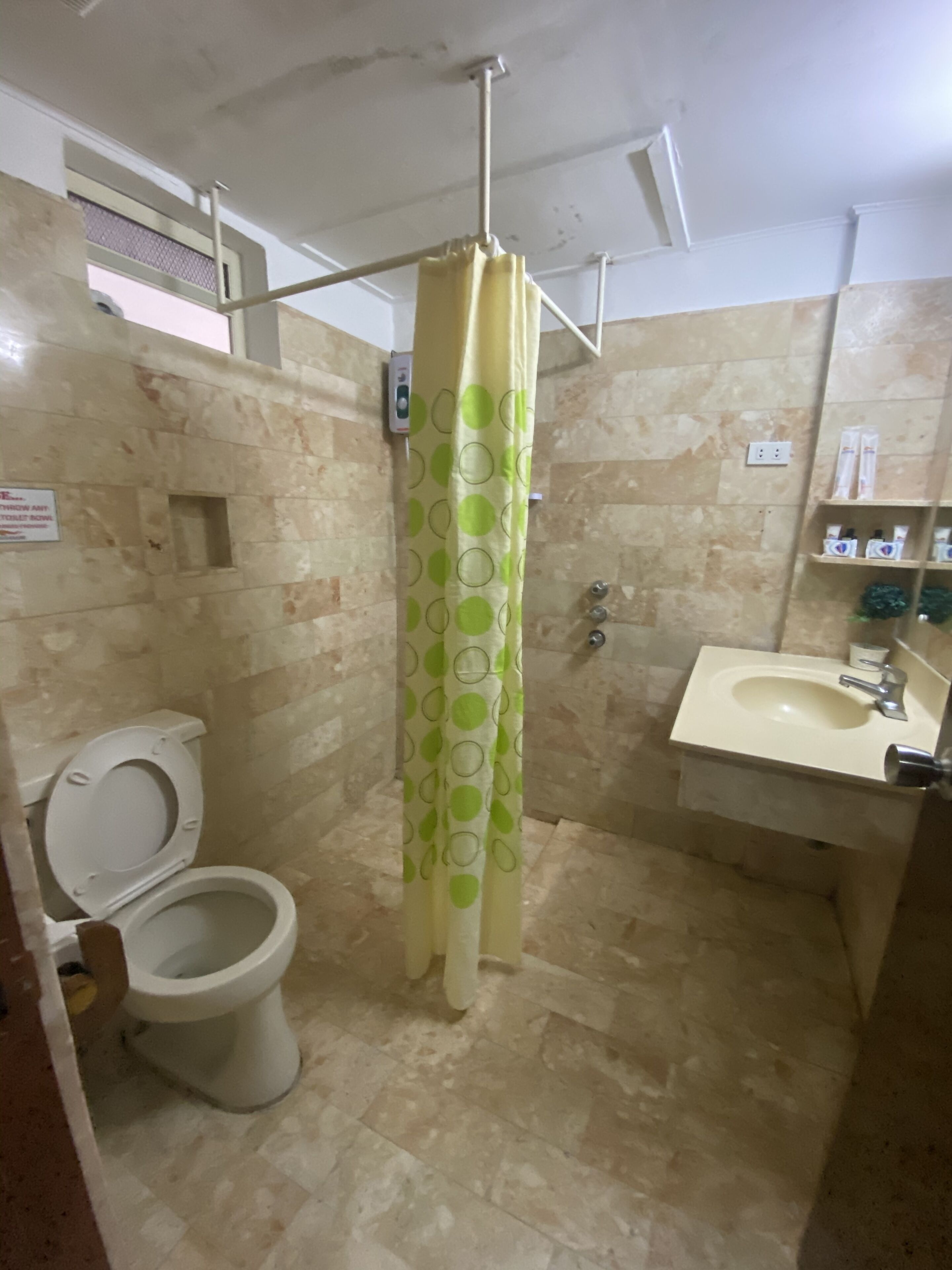 Un baño con inodoro, lavamanos y cortina de ducha.