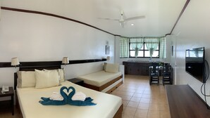Una habitación de hotel con cama, mesita de noche, lámpara y televisor.