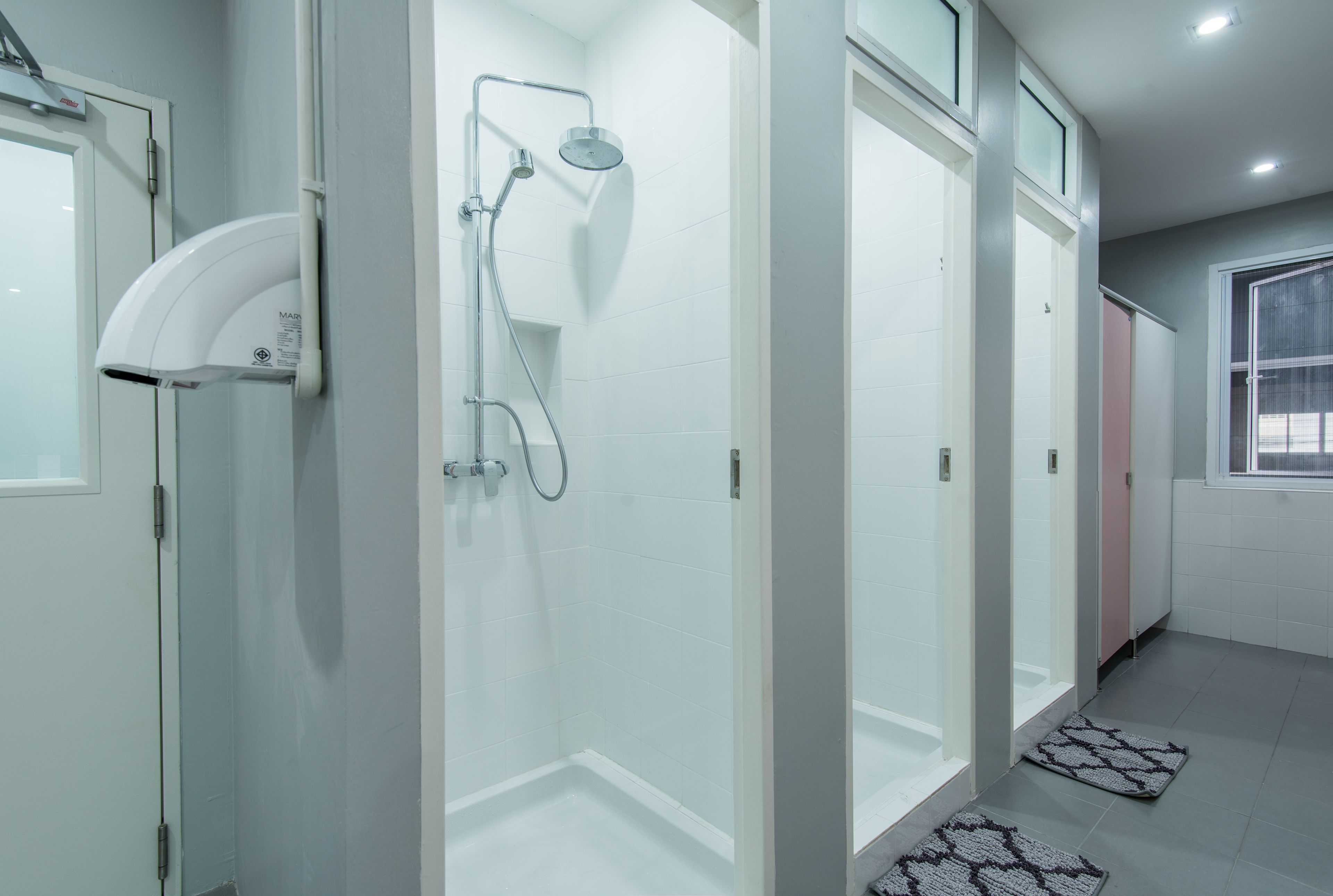 Un baño moderno con ducha de vidrio, lavamanos blanco y tocador con espejo.