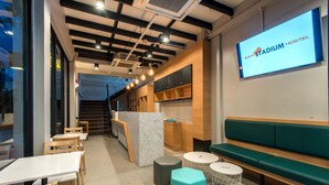 Ein modernes Hostel-Interieur mit Rezeption, Sitzbereich und einer Treppe zu den oberen Ebenen.