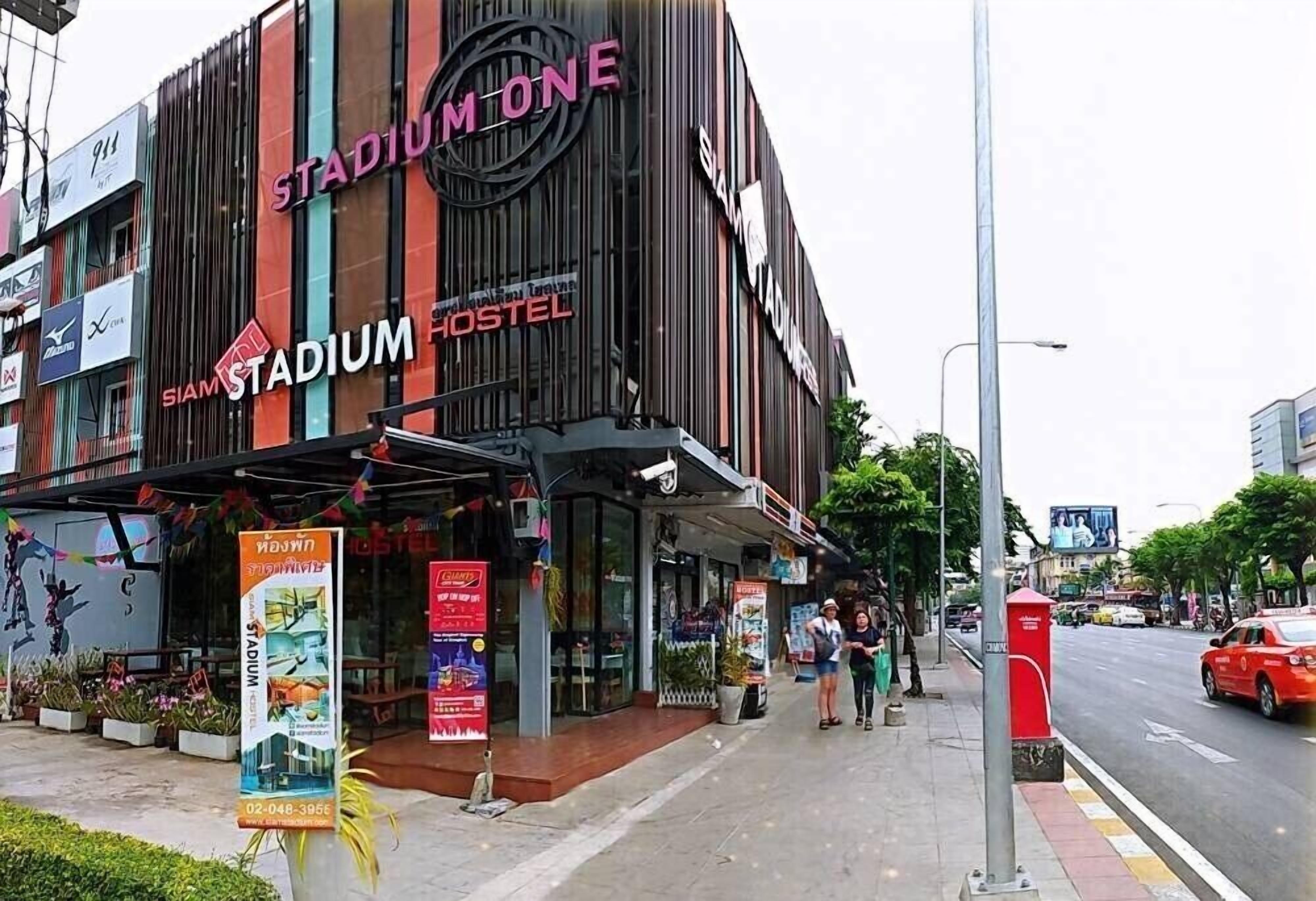 A building with a sign reading "STADIUM HOSTEL" and "STADIUM ONE".