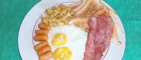 Un plato con tostadas, huevos, salchichas y patatas.