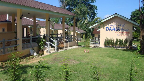 A bungalow-style house with a covered porch and a sign indicating it is available for rent. - Dahla House Ranong (Ranong)