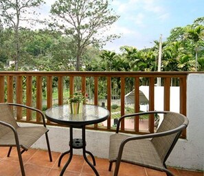 Relax on the balcony with a round table and two wicker chairs, taking in the serene views of the lush landscape.