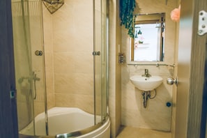 A bathroom with a glass-enclosed shower, a white bathtub, and a sink with a mirror above it.