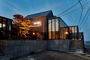 A modern building with a sign reading "REVOIR" and a staircase leading to an entrance. - Revoir (Pohang)