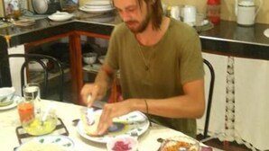 A person sitting at a round dining table with various dishes, including toast, fruit, and a bowl of red sauce. - Mount view 11 (Kandy)