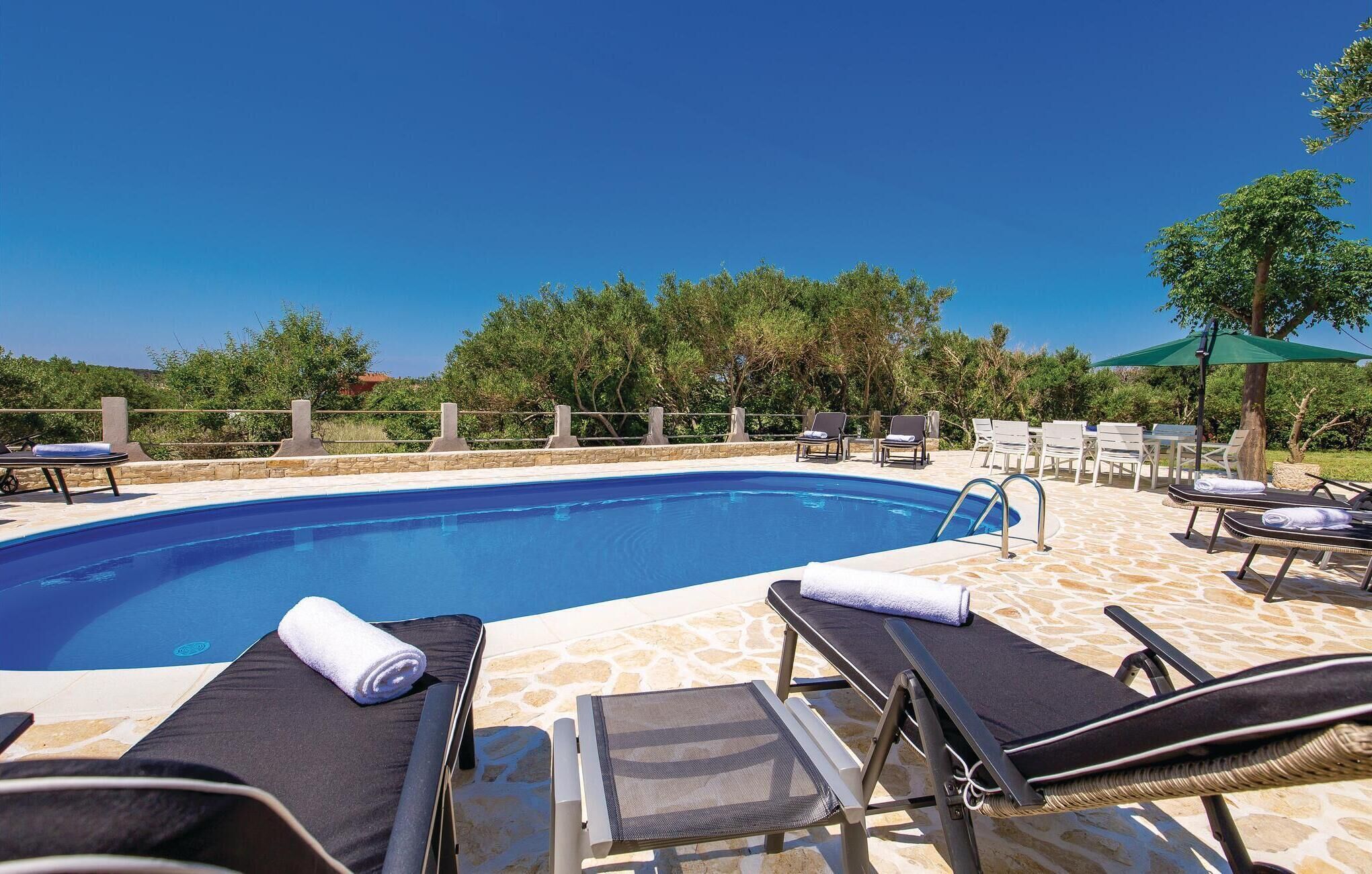 Un espace aménagé au bord de la piscine, avec des chaises longues, une piscine et une terrasse dallée de pierres.