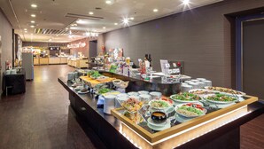 A buffet with various dishes and beverages, a wooden floor, and a modern ceiling design.
