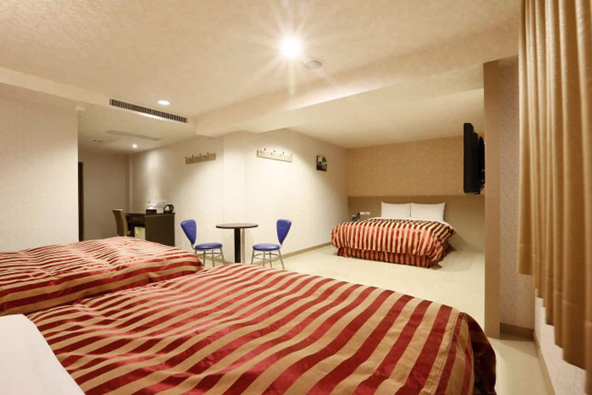 Ein Hotelzimmer mit zwei Betten, einem Schreibtisch und zwei Stühlen.