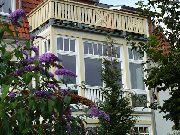 En byggnad med flera våningar, stora fönster och en balkong.