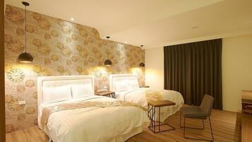 A hotel room with two beds, a small table, a chair, and a wall with a clock pattern.