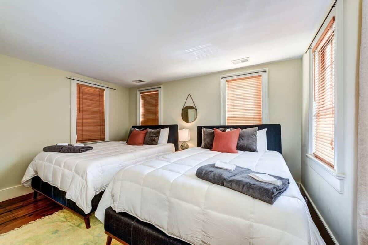 A double room with two beds, a bedside table with a lamp, and a mirror on the wall.