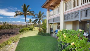 A two-story building with a balcony, a well-maintained lawn, and palm trees. - Mauna Lani Private beach access, 2026 Hilton Waikoloa Pool pass included! (Waimea)