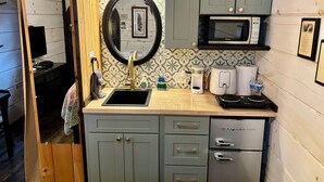 A compact kitchen with a sink, microwave, and a refrigerator. - #1 Olga - *New Kitchen* Tiny Home Cottage (Sevierville)