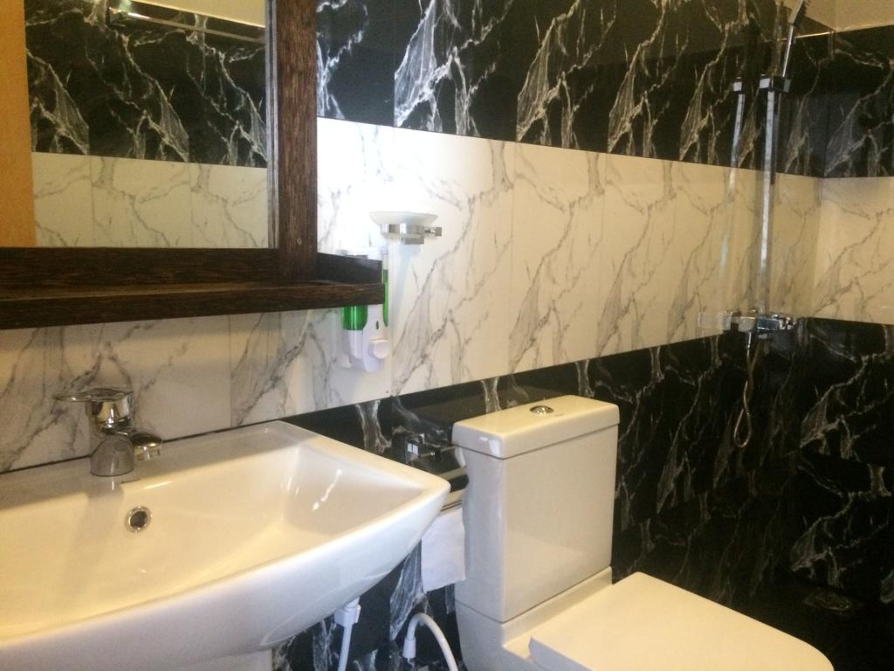 A bathroom with a white sink, a toilet, and a shower.