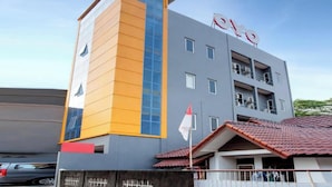 A modern building with a prominent 'BAY' sign on the roof, a vertical orange and blue facade, and a tiled roof. - Hotel O Sarkawi Residence (Jakarta)
