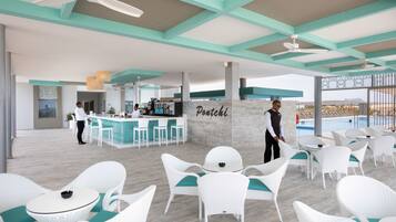 A modern outdoor seating area with white wicker furniture and teal cushions, a bar area with a bartender, and a view of the landscape.