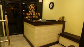 A hotel reception desk with a sign reading "Hotel Shri Ram Residency."