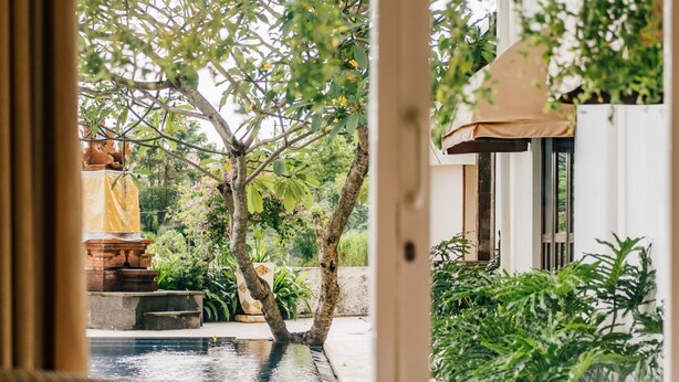 A room with a view of a water feature and greenery outside. - Umpadhi Canggu Hotel (Canggu)