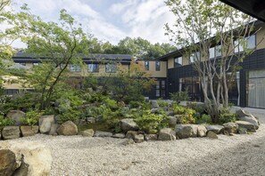 A modern building with a landscaped garden featuring rocks and trees.