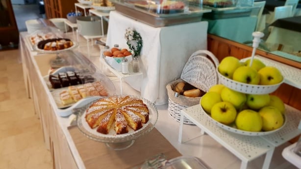 A buffet with various food items including a cake, bread, and apples. - Hotel Riva (Rimini)