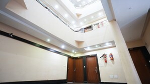 A multi-level interior with a skylight, wooden doors, and a fire extinguisher. - HOTEL MADURAI (Udaipur)