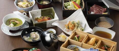 A variety of Japanese dishes arranged on a table, including sushi, sashimi, and other traditional foods.