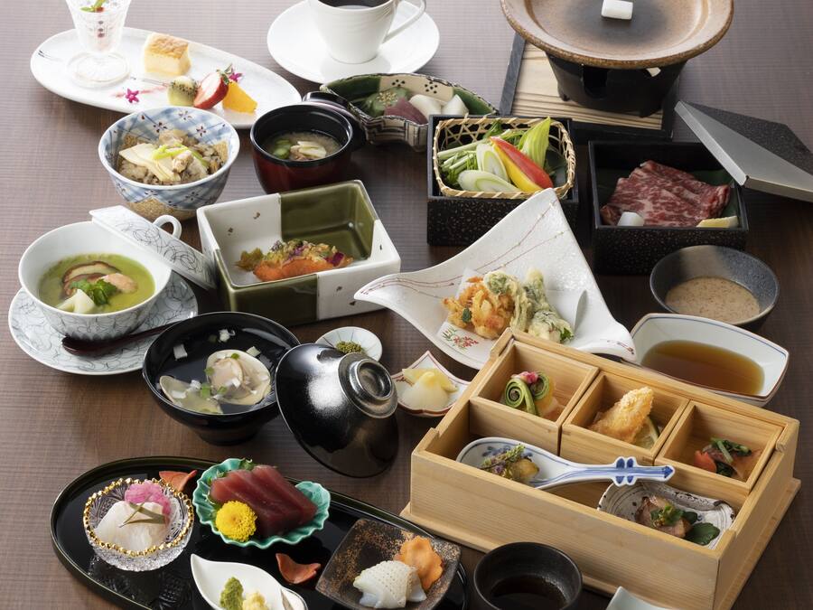 A variety of Japanese dishes arranged on a table, including sushi, sashimi, and other traditional foods.