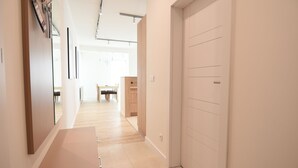 Ein Flur mit einer Holzbank, einem Spiegel und einer Tür zu einem Essbereich.