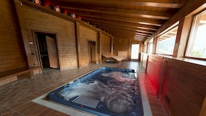 Una cabaña de madera con un jacuzzi en el centro.